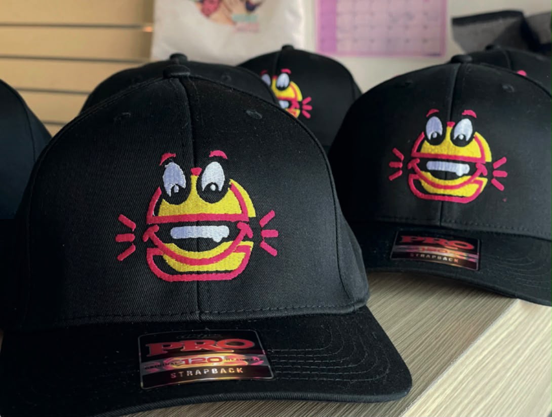 Bordado de logo dorado en gorra premium por Aquí Bordamos